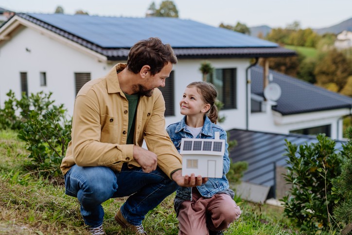 Bild von Mann mit Tochter vor Solaranlage auf eigenem Dach